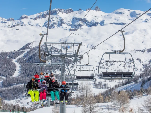 Famille sur un télésiège permettant d'accéder sur les hauteurs du domaine skiable
